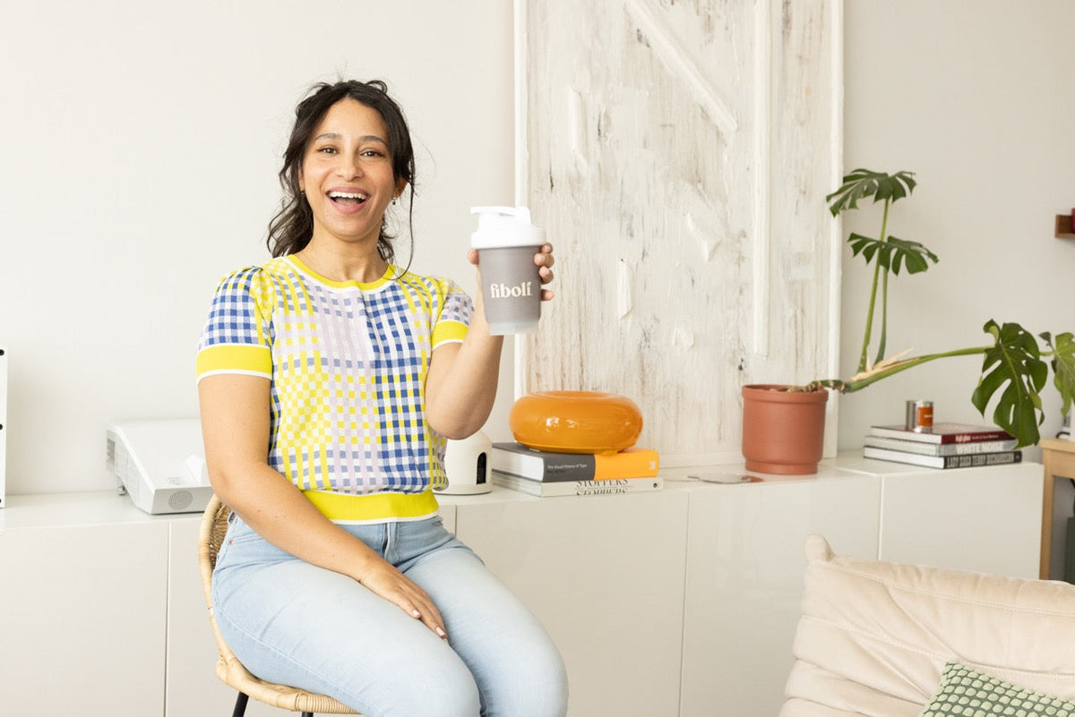 Rania holding a fiboli shaker wearing bright colours.