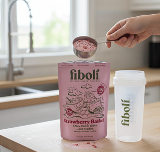 Person measuring fiboli strawberry basket powder with a spoon in a kitchen setting