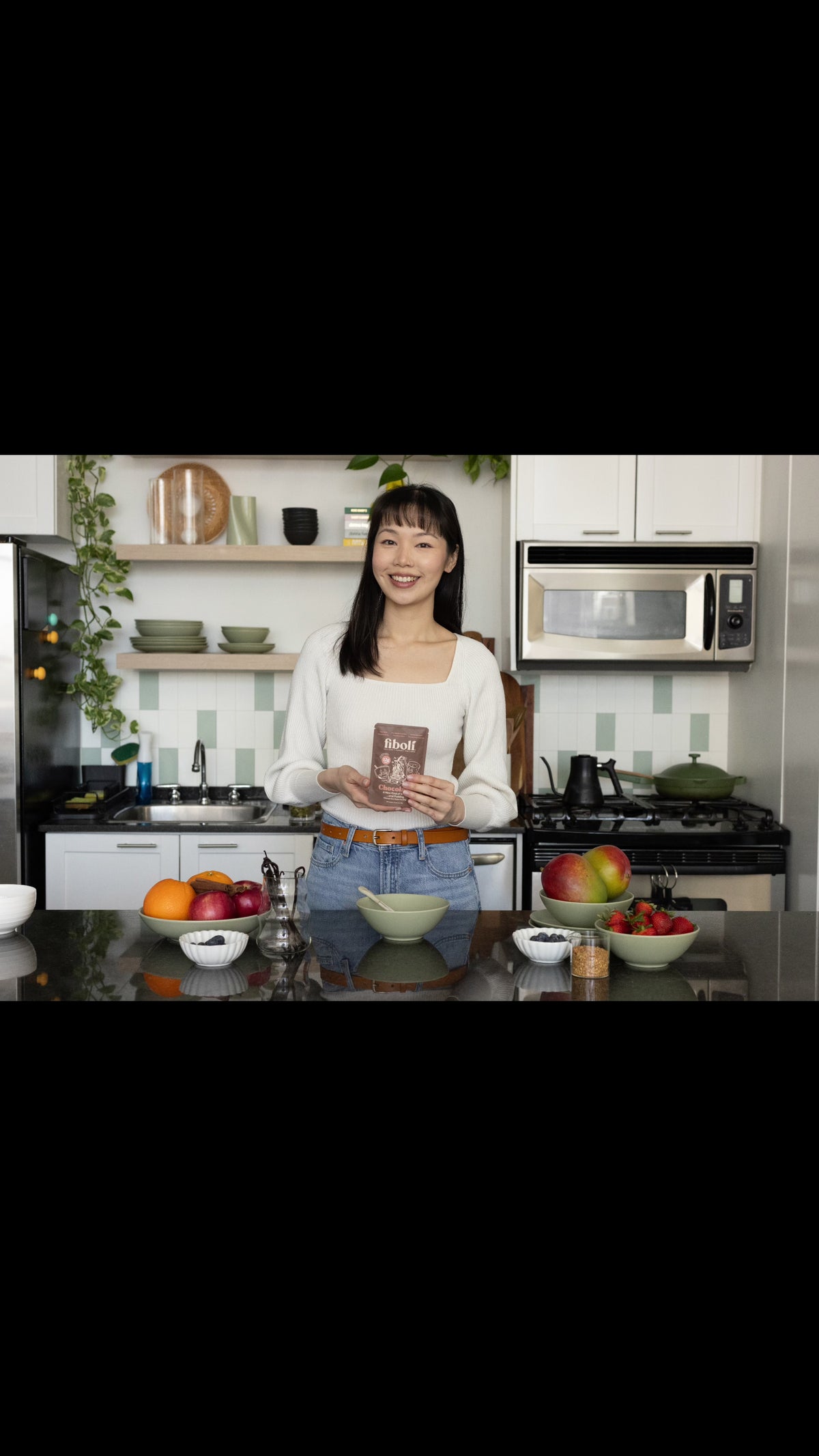 Young woman in her kitchen mixing fiboli cocoa dry mix with milk into a creamy pudding, in a bowl.